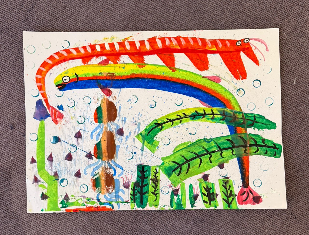 筆を使わずに描いた、赤・青・緑の生きものが広がる作品